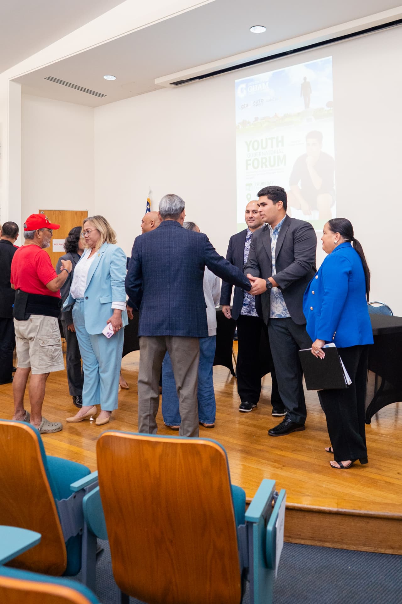 Genesis Babauta greeting candidates and guests at the forum